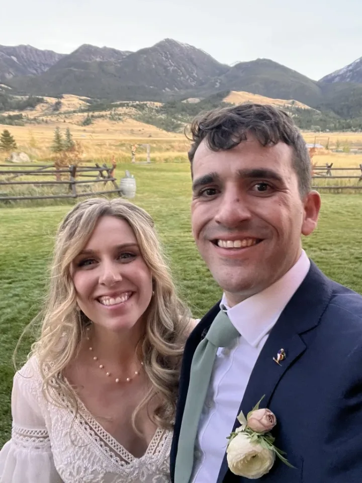 Nicholas and his family smiling together in the mountains